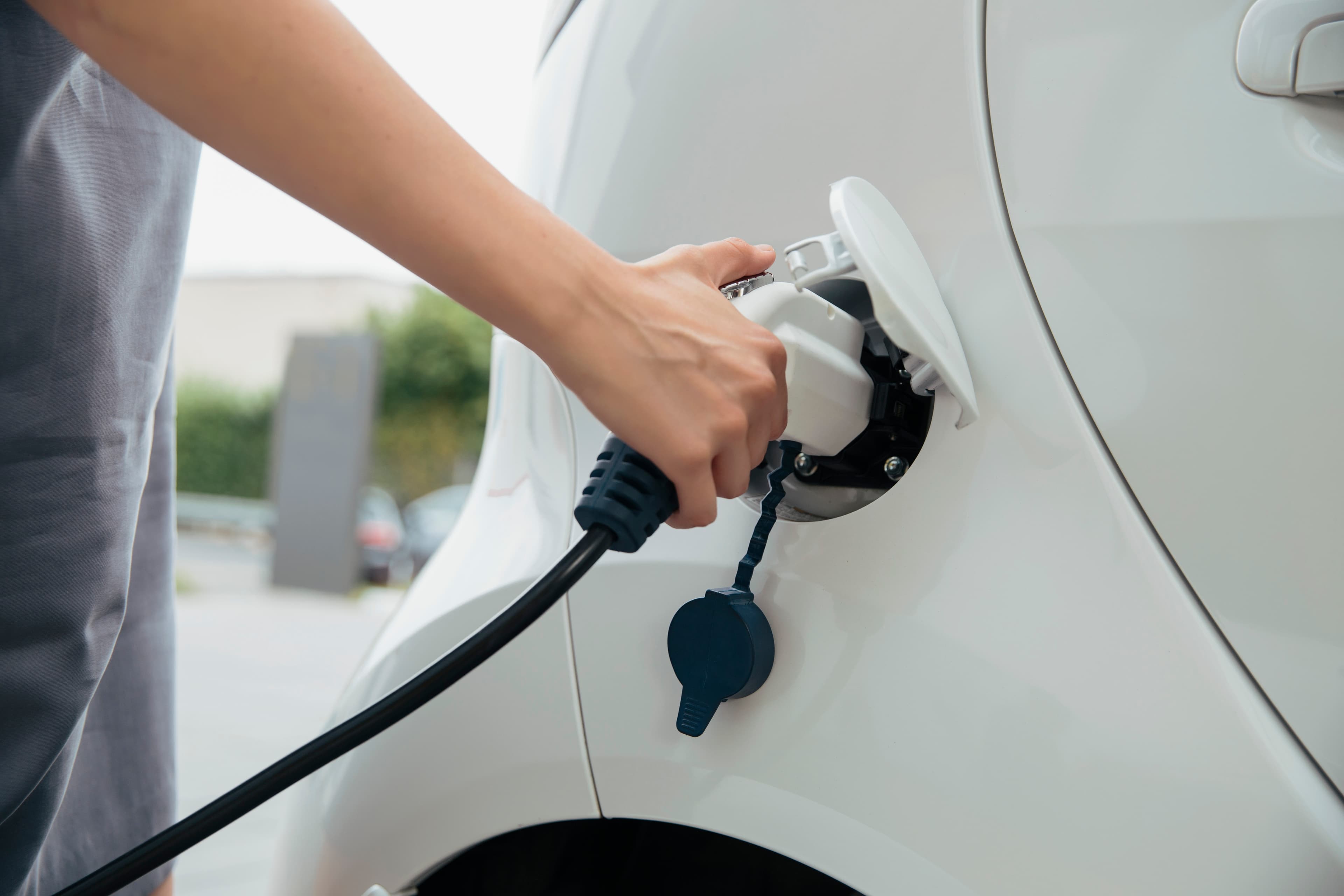 close up of white electric vehicle being charged