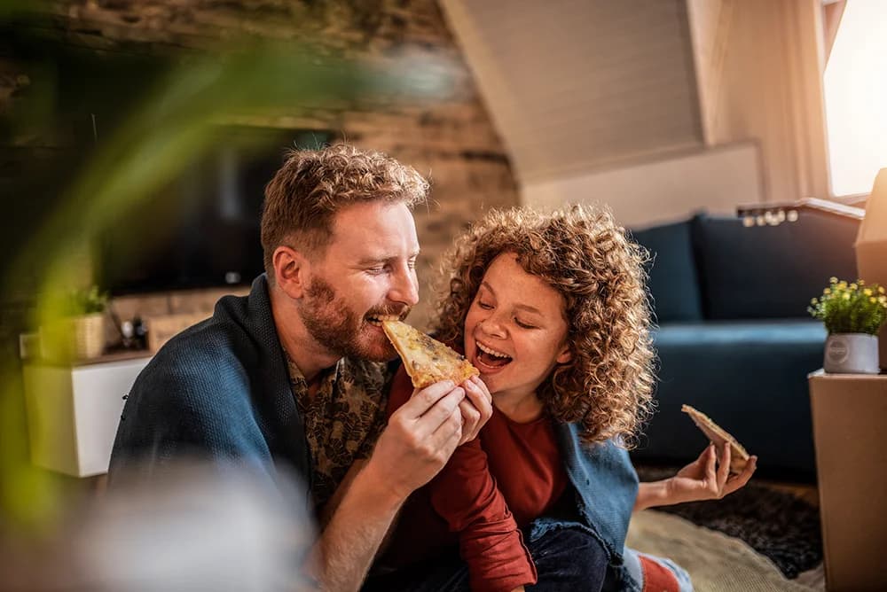 Couple moving in to new place eating pizza