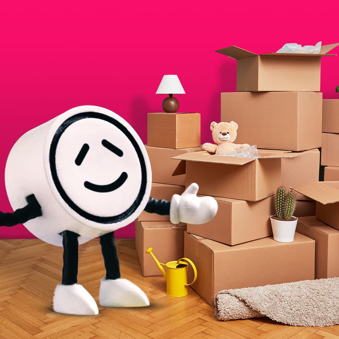 Winky the Powershop mascot standing next to packing boxes for moving house